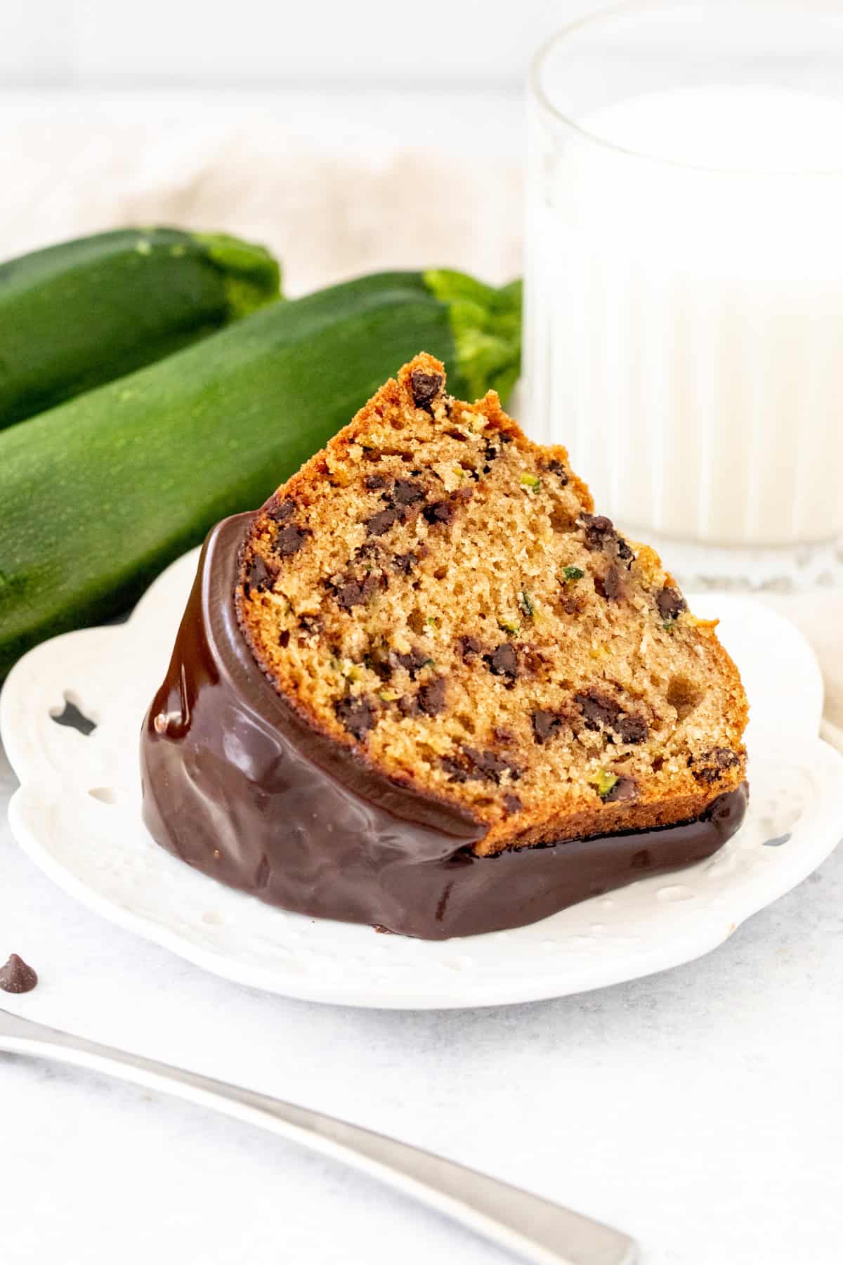 slice of zucchini bundt cake with chocolate chips and chocolate drizzle on top