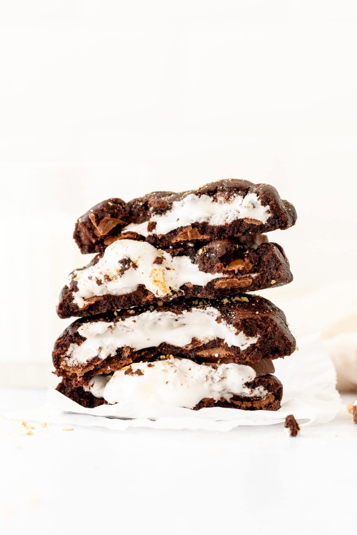 stack of chocolate s'mores cookies, broken in half and stacked on top of one another