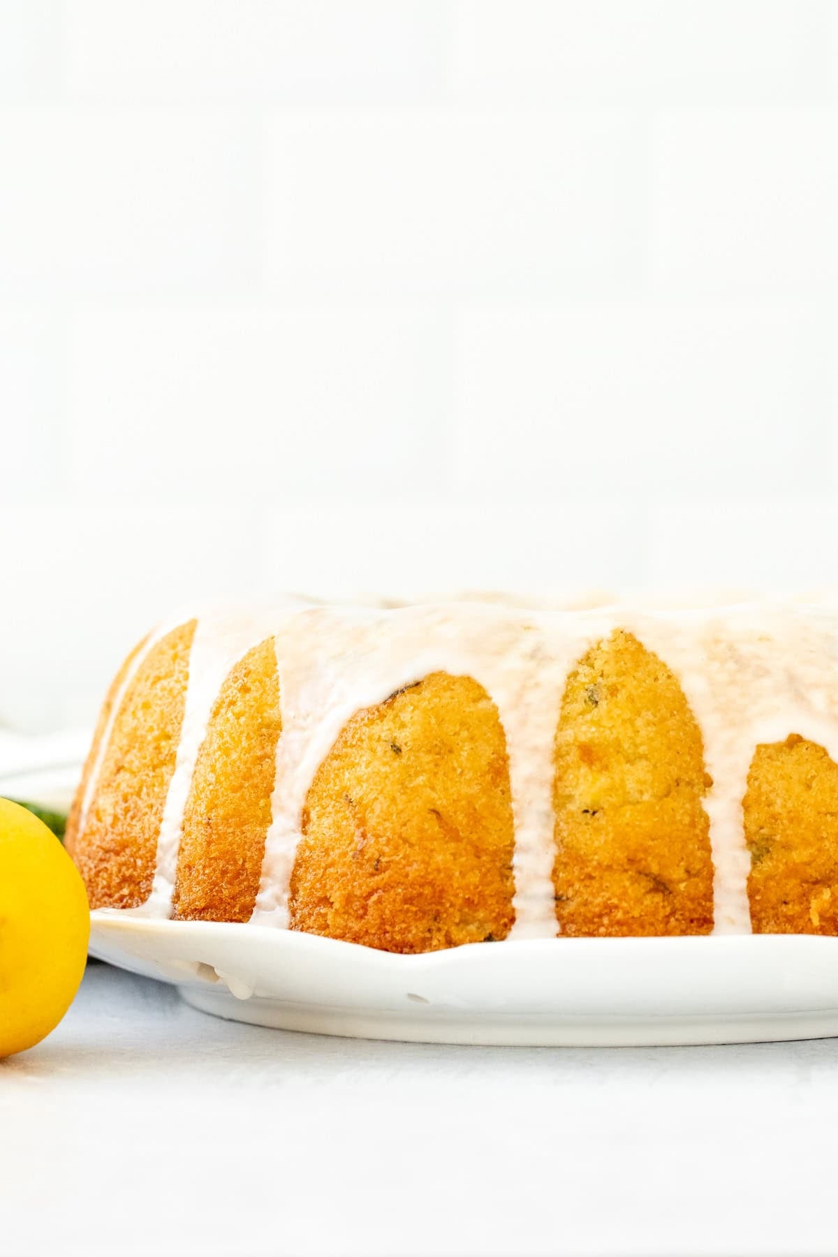 lemon zucchini bundt cake topped with a drizzle of lemon glaze.