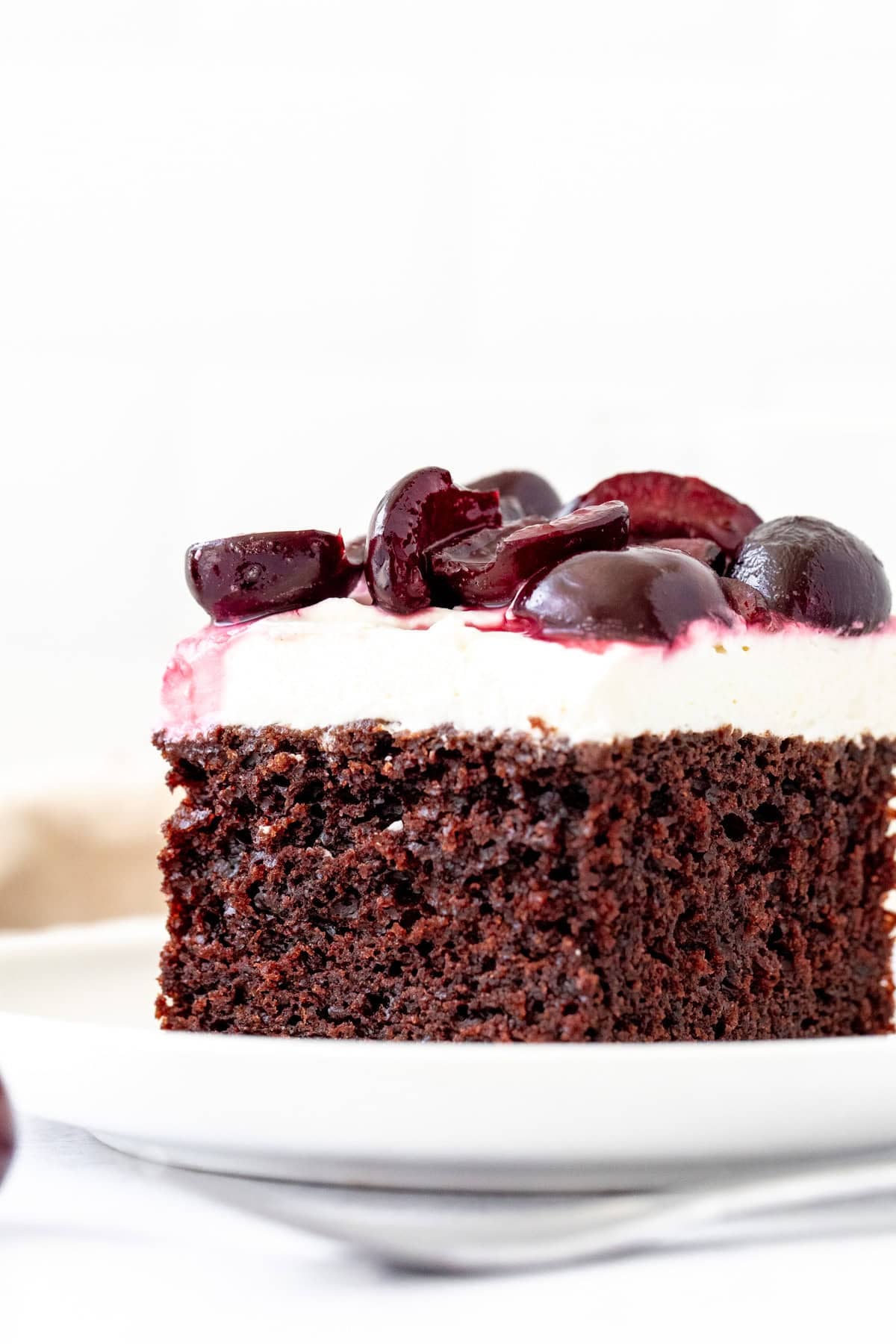 slice of black forest sheet cake with whipped cream and cherries on top