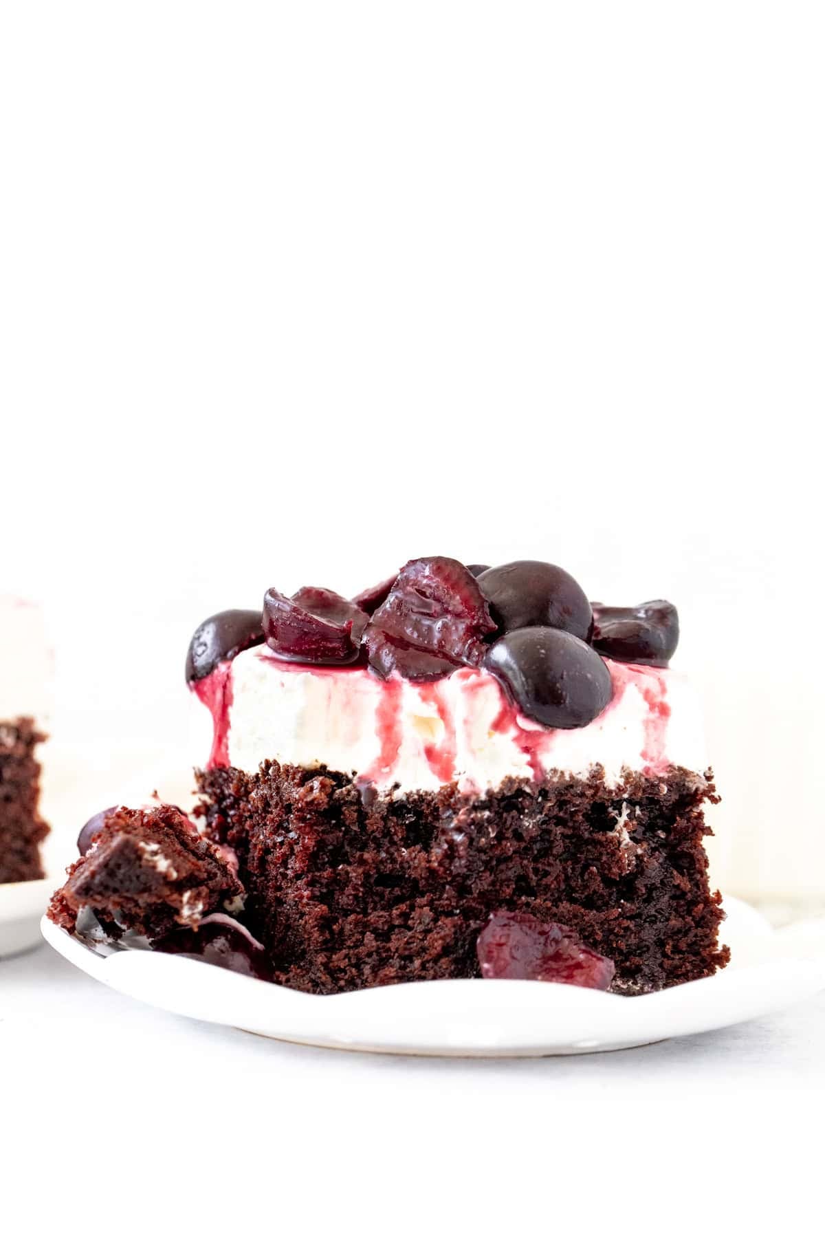 Slice of fudgy black forest cake with a bite taken out