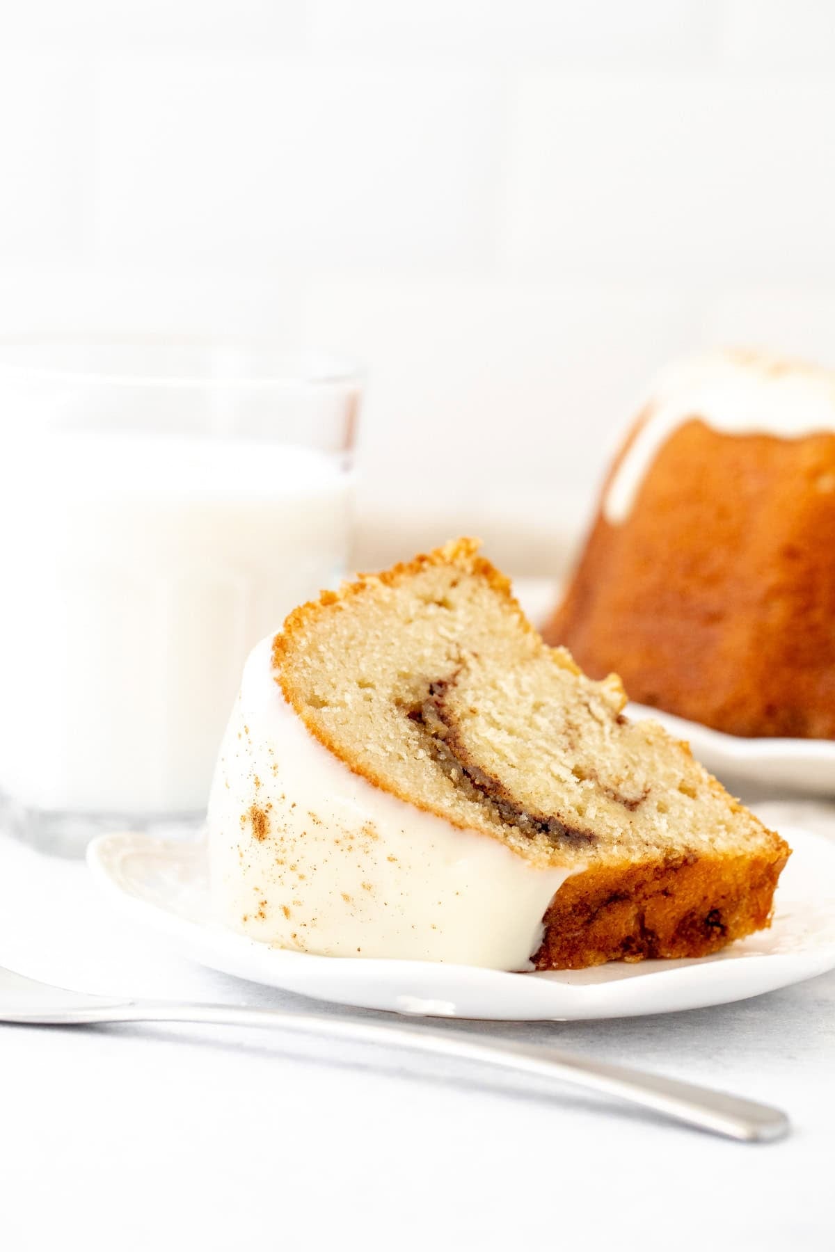 Slice of cinnamon bundt cake with cream cheese icing on top