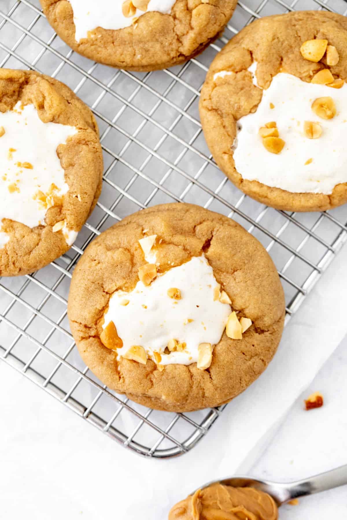 fluffernutter cookies with marshmallow fluff in the middle on a cooling rack