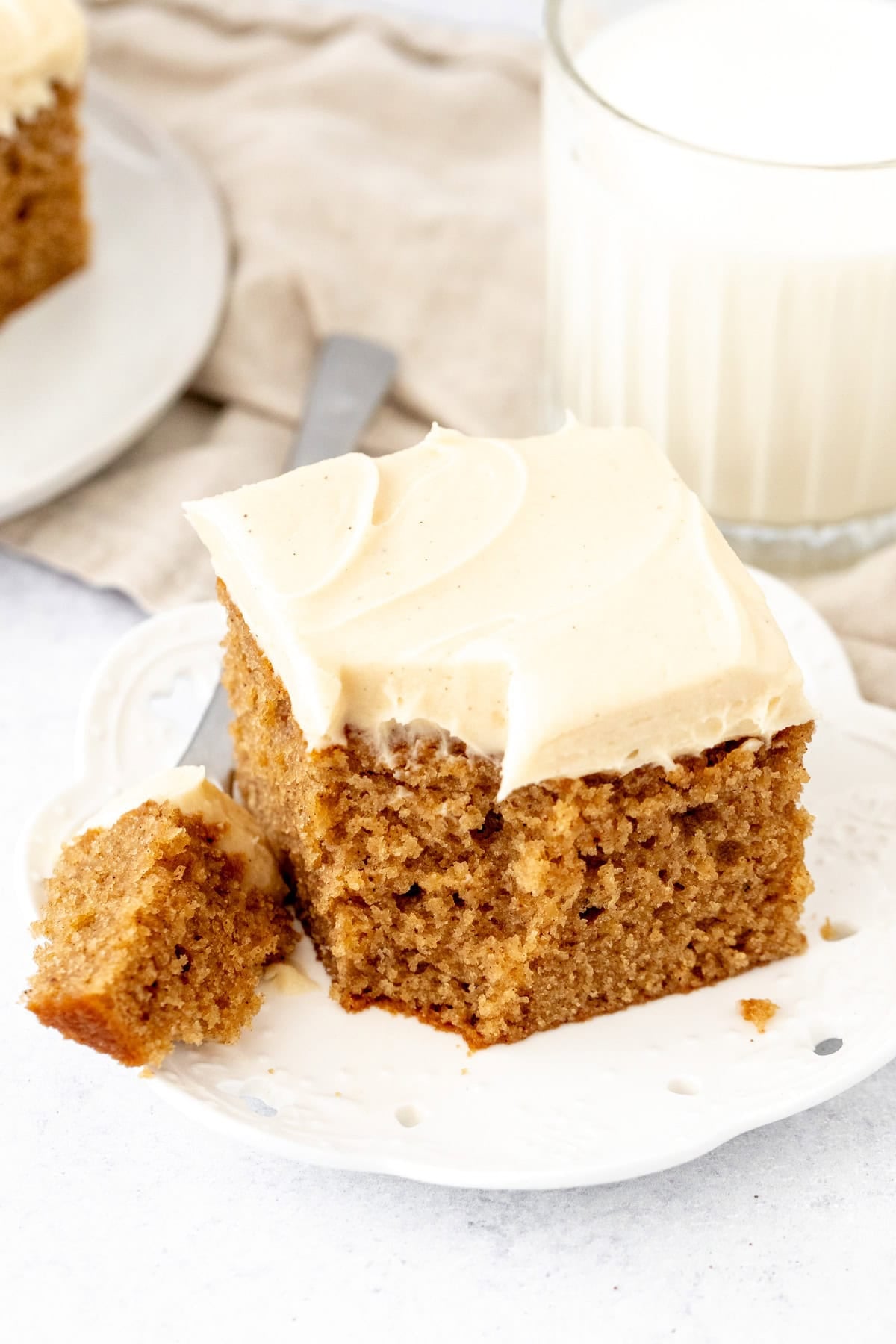 Moist spice cake topped with brown butter cream cheese frosting with a bite taken out of it