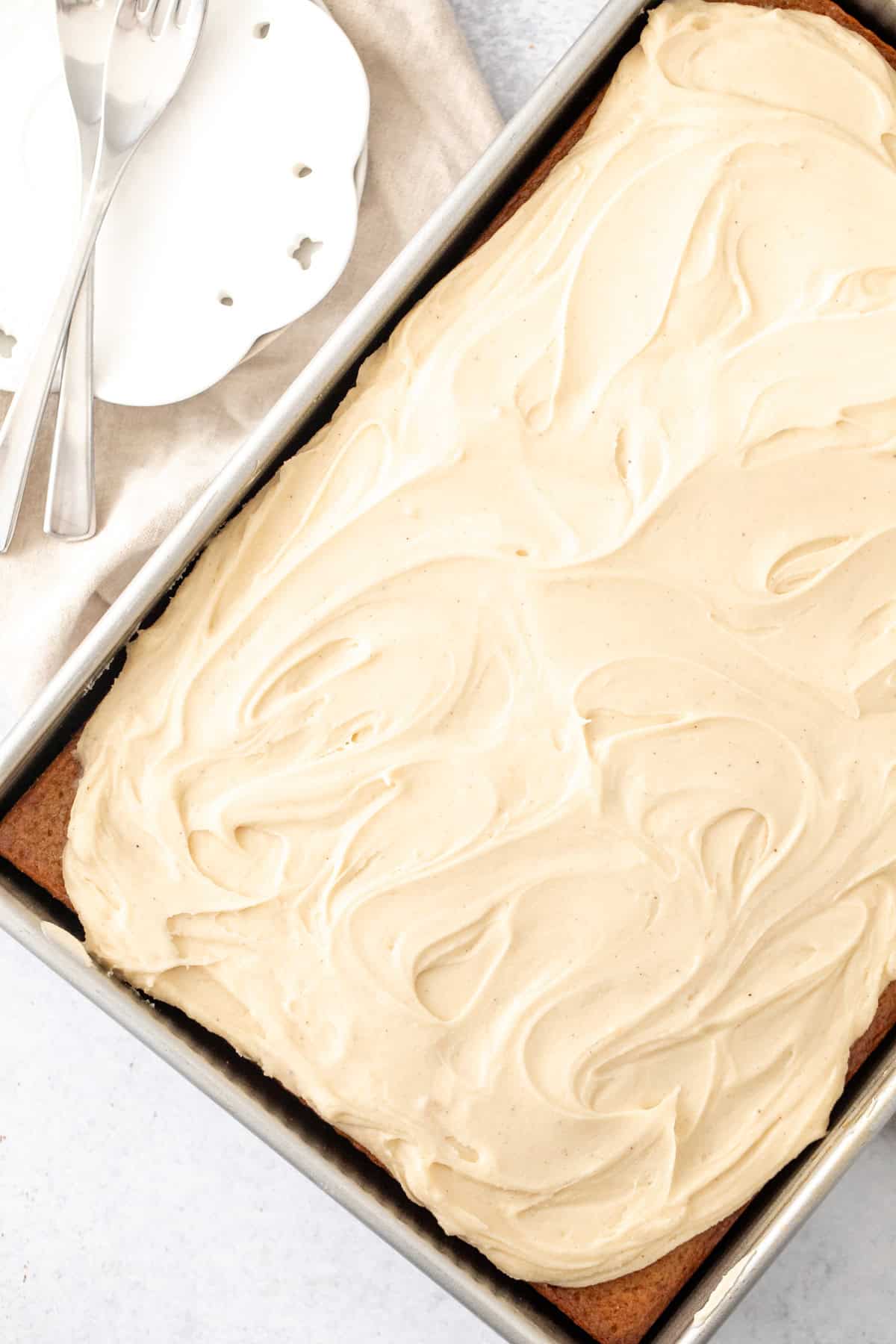 sheet pan of spice cake topped with brown butter cream cheese frosting