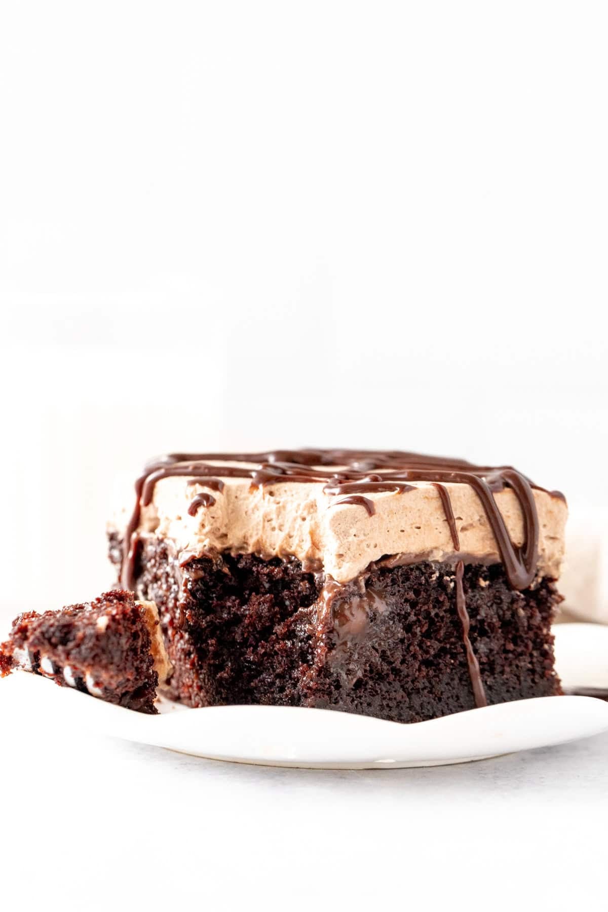 Triple chocolate poke cake with a bite taken out