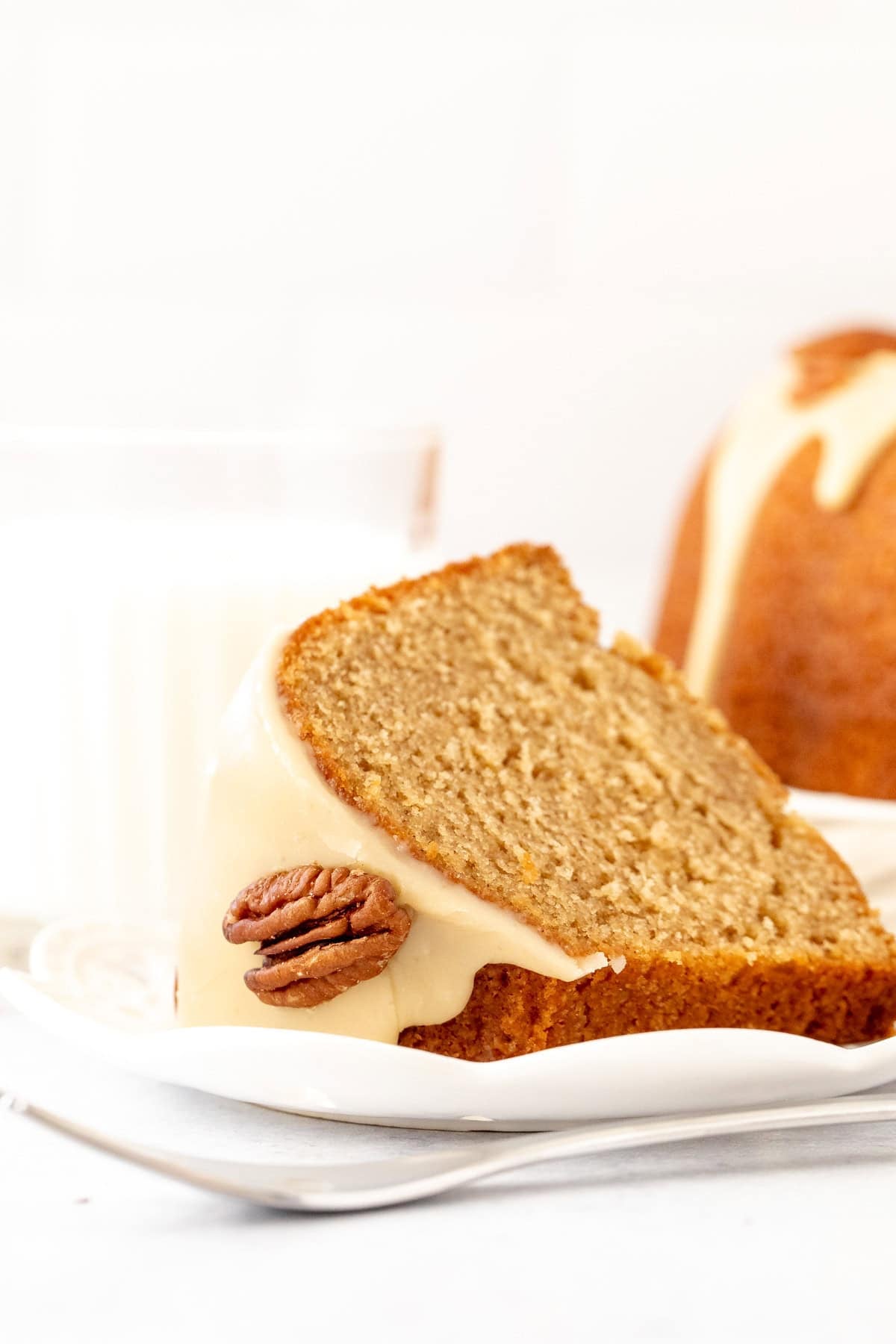 slice of maple bundt cake with a glass of milk